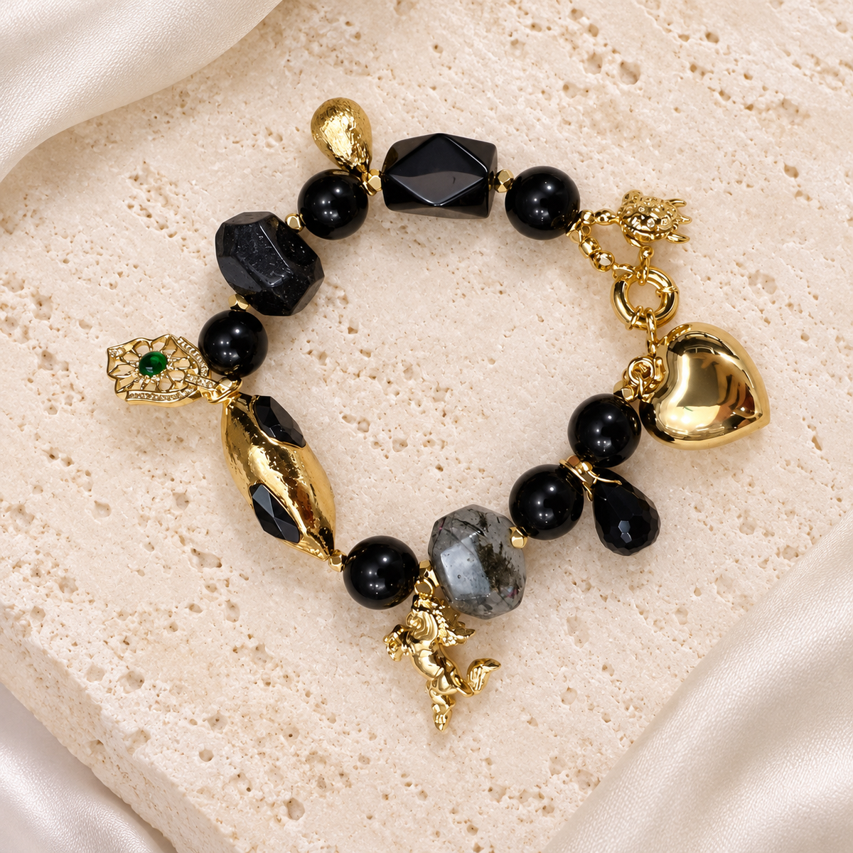 Midnight Agate Charm Bracelet — full bracelet on a cream stone surface