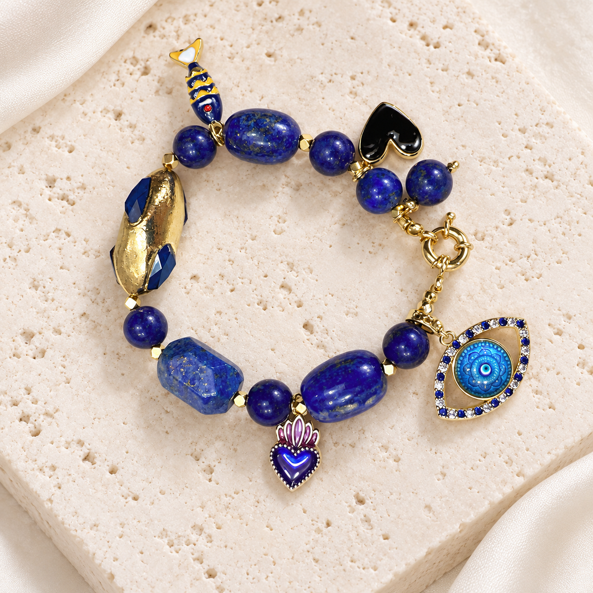 Lapis Blue Eye Charm Bracelet — full bracelet on a cream stone surface
